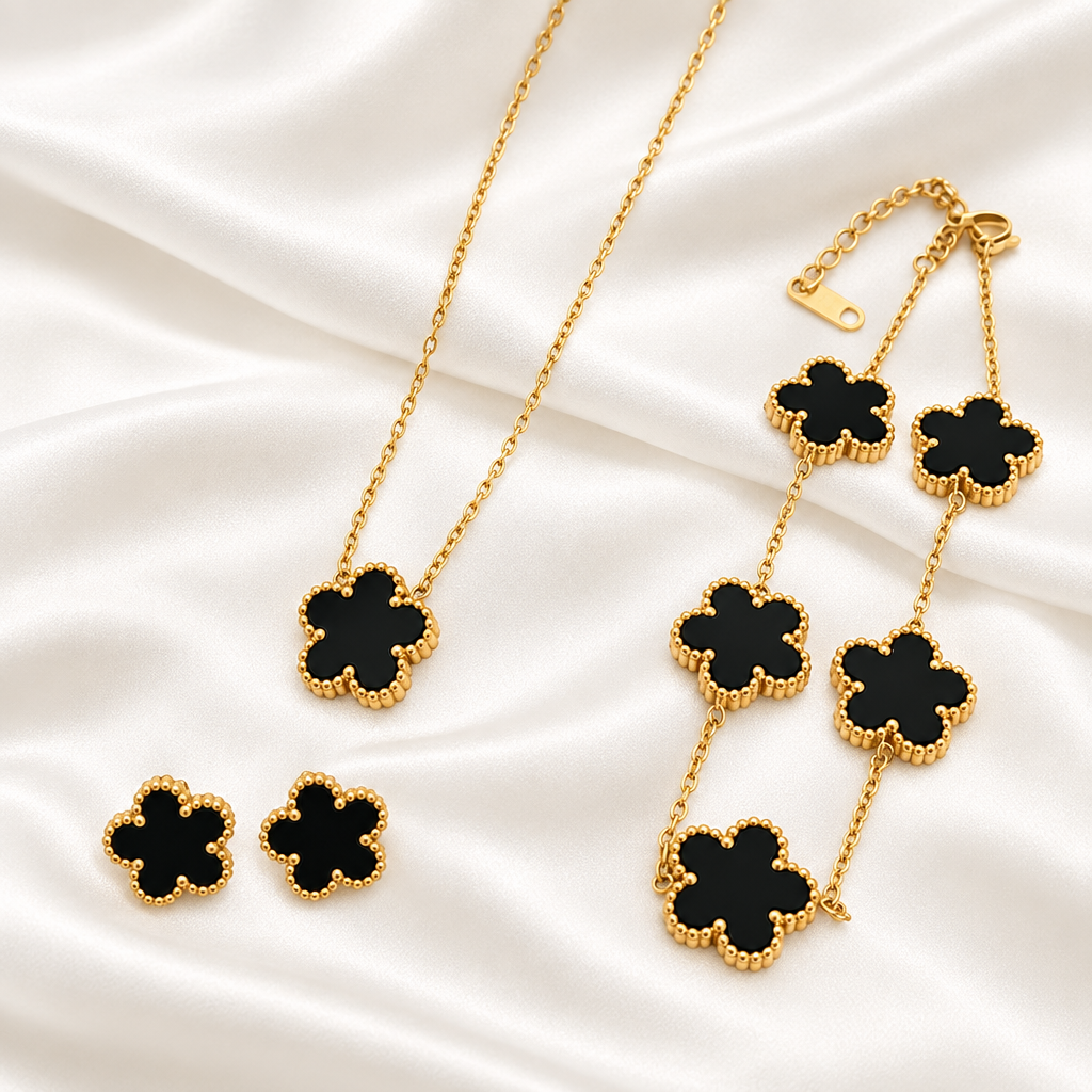 Black flower pendant necklace, bracelet and matching earrings on satin