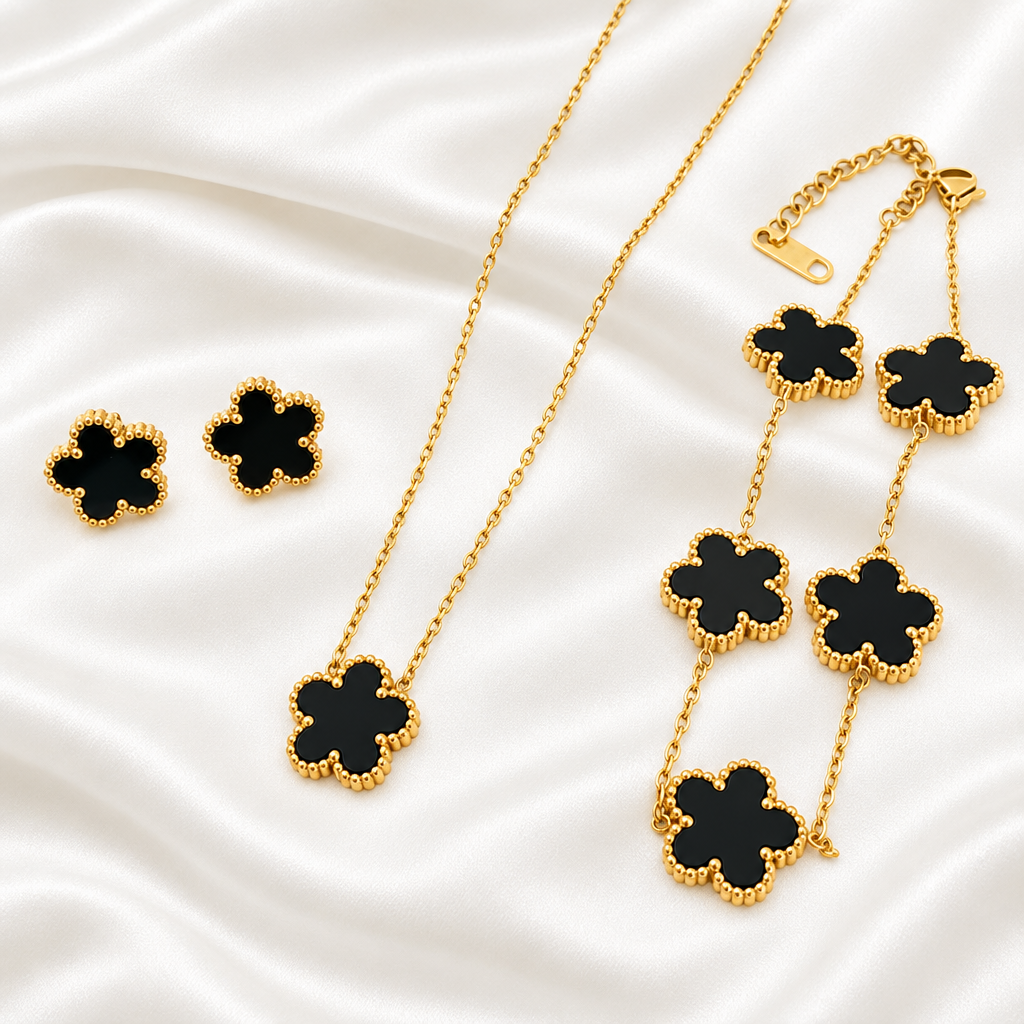 Black five-petal flower necklace, bracelet and earrings on white satin